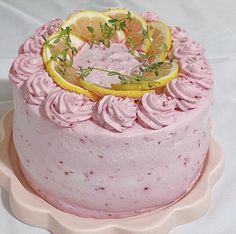 a cake with pink frosting and lemons on top