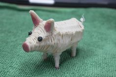 a small toy pig sitting on top of a green blanket