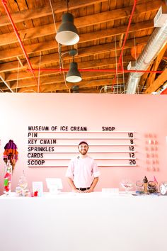 a man standing in front of a counter with ice cream on it's side