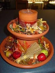 a candle is sitting on top of two bowls filled with autumn leaves and apples in the center