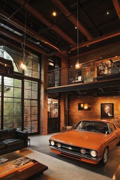 an orange car is parked in the middle of a room with exposed ceilings and large windows