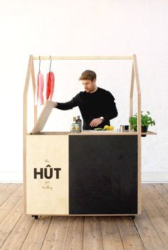 a man standing behind a food cart with fish on it