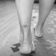 a woman's foot with an eye tattoo on the left side of her leg