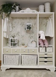 a white shelf filled with baskets next to a wallpapered wall covered in flowers