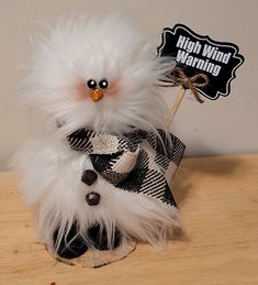 a white bird with black and white feathers on it's head sitting on a table