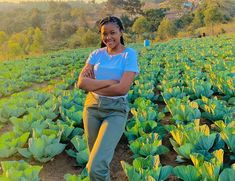 a woman standing in a field with her arms crossed