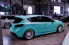 a blue car parked in a garage next to other cars