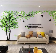 the living room is decorated with green trees and birds on the wall, along with a white sofa