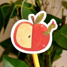 an apple sticker with a worm sticking out of it