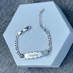 a personalized bracelet is shown on a white display box with a silver chain and crystal stones