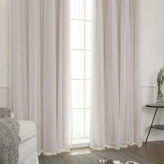 a living room with white walls and curtains