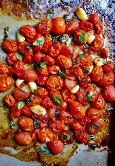 roasted tomatoes and basil on a baking sheet