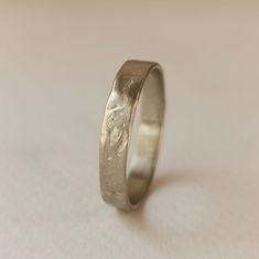 a close up of a wedding ring on a white surface with no one in it