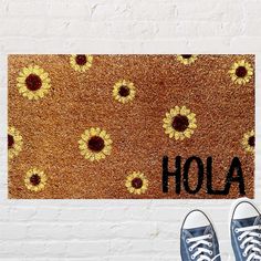 a door mat with the word hola written on it and two pairs of shoes