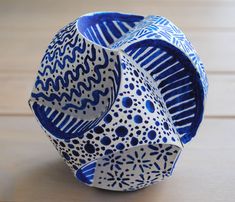 a blue and white vase sitting on top of a wooden table