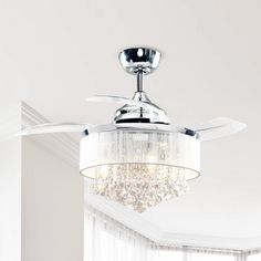 a chrome ceiling fan with crystal chandelier hanging from it's blades in a white room