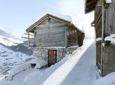 an old building is covered in snow on a mountain