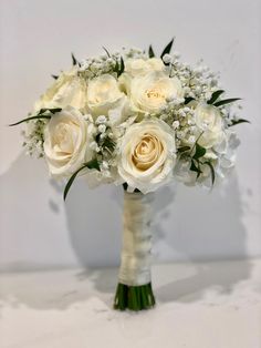 a bridal bouquet with white roses and baby's breath