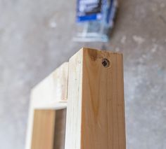 a piece of wood that is sitting on the ground next to a bottle of glue