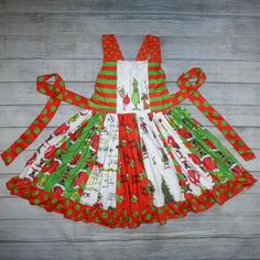 a child's christmas dress made out of fabric on a wooden background with red, green and white stripes