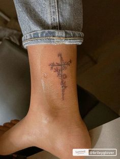 a person with a cross tattoo on their foot