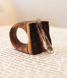 a wooden ring with two crystal beads on top of an open page of a book