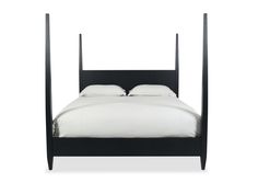 a black bed frame with white sheets and pillows on the headboard, in front of a white background