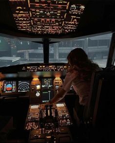 a woman is sitting in the cockpit of an airplane