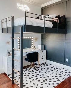 a black and white bedroom with a loft bed, desk and chair in the corner