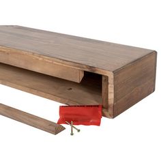 a wooden desk with a red bag on the bottom and two pieces of wood underneath it