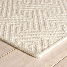 a white rug on top of a wooden floor next to a wood flooring board