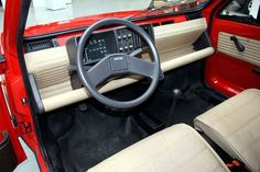 the interior of a red car with beige leather seats