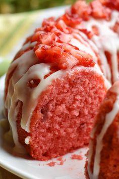 a red cake with white icing and strawberries on top sitting on a plate