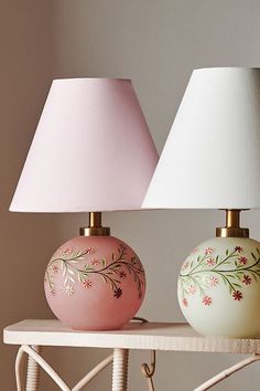 two lamps sitting on top of a table next to each other with one light turned on