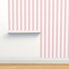 an empty room with pink and white stripes on the wall, next to a shelf