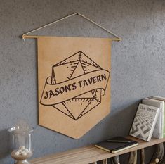 a wooden sign hanging from the side of a wall next to a shelf with books