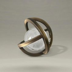 an object that looks like a sphere with two rings around it and a light bulb in the middle