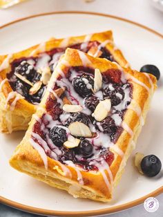 two blueberry waffles on a white plate with almonds and drizzled in icing