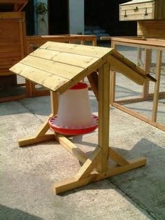 a wooden bird house with a red and white bucket