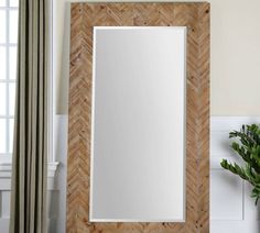 a mirror sitting on top of a table next to a plant