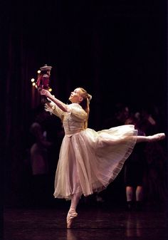 a young ballerina is performing on stage