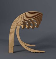 a wooden sculpture with curved sections on the top and bottom, sitting in front of a gray background