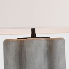 a table lamp with a white shade on it's side and a black base