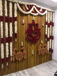 the wall is decorated with red and white garlands, hanging on wood panels that are adorned with flowers