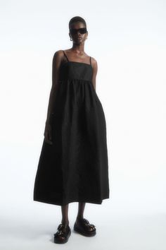 The classic black dress takes on a new dimension in this piece from our Summer 2023 collection. Suspended from slender spaghetti straps, it's shaped with a straight-cut empire neckline and has a voluminous, full skirt and subtle pockets that you can slip your hands into. Look closely at the recycled fabric to see its subtle texture. Regular fit, midi lengthSide-seam pocketsA better alternative to conventional polyester, recycled polyester is made from pre‐ and post‐consumer waste  100% Recycled Cos Dress, Black Spaghetti Strap Dress, Lacey Dress, Classic Black Dress, Midi Dress Casual, 2023 Collection, Midi Shirt Dress, Blue Midi Dress, Tea Dress