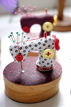 a sewing machine sitting on top of a wooden box next to some buttons and needles