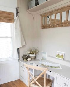 a white desk and chair in a room with wood flooring, windows, and wooden blinds