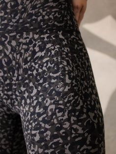 a woman in black and white patterned leggings with her hand on her hip