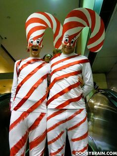 two people dressed in costumes standing next to each other with candy canes on their heads