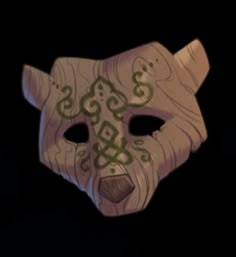 a white mask with green designs on it's face is shown in the dark